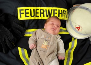 Baby mit Feuerwehr-Outfit