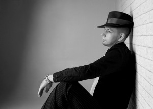 Portrait – Mann sitzend vor Mauer in schwarz-weiß
