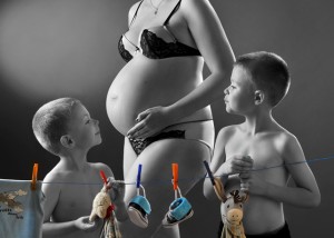 Schwangere mit Söhnen, die Wäsche aufhängen